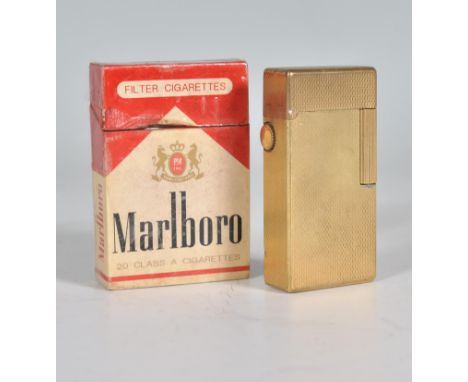 A vintage 20th Century Dunhill roller gas cigarette lighter of rectangular form having a gilt engine turned body. Stamped to 