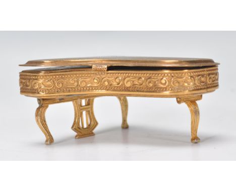 A vintage mid 20th Century ladies Pygmalion compact in the form of a piano, having articulated folding legs with mirror to th