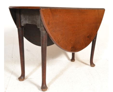 A 19th century George III solid mahogany pad foot dining table having gate leg action supporting the drop leaves. Measures 72