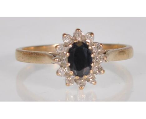 An English hallmarked 9ct yellow gold ladies ring set with a central faceted cut oval black stone with diamond accent stones 