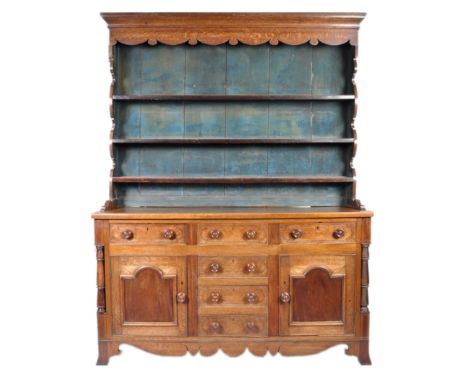 A 19th North Country oak dresser having a waterfall three tier shelf plate rack back with carved apron. Three drawers over ce