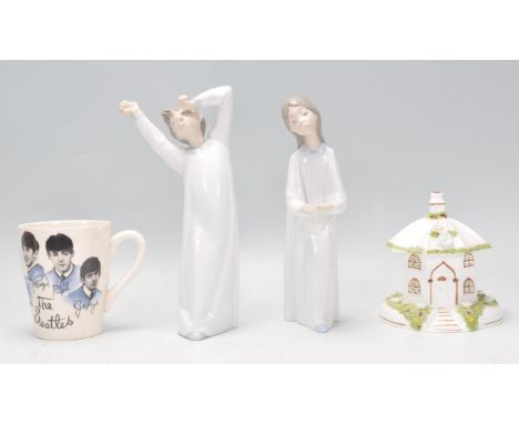 A pair of Lladro porcelain figurines, each of children in night gowns being stamped to the base together with a Coalport past