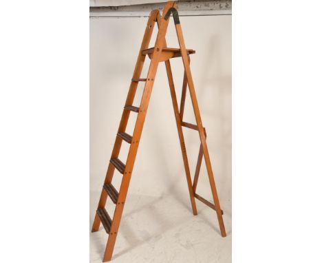 A vintage early 20th Century wooden Industrial folding step ladder / shop display having six steps. Measures 230 cm high.