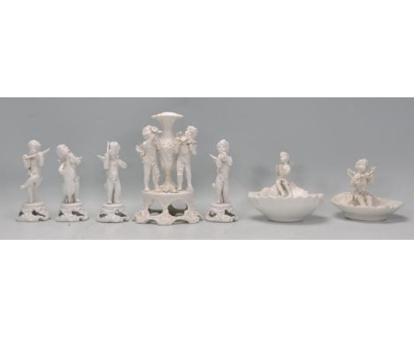 A collection of Italian porcelain cherub figurines to include oyster shell table salts, solifleur vase with diorama cherub ba