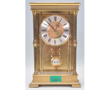A vintage 20th Century Acctim mantel clock having a brushed brass case with turned columns with a round silvered chapter ring