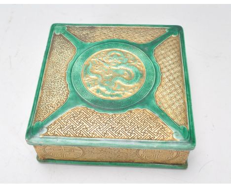 An early 20th Century Chinese ceramic box of square form having green glazed borders with dragon decoration atop the cover wi