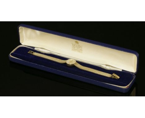 A ladies 9ct gold Garrard mechanical bracelet watch,with a circular silvered dial, raised gilt batons and hands.  Integral Mi