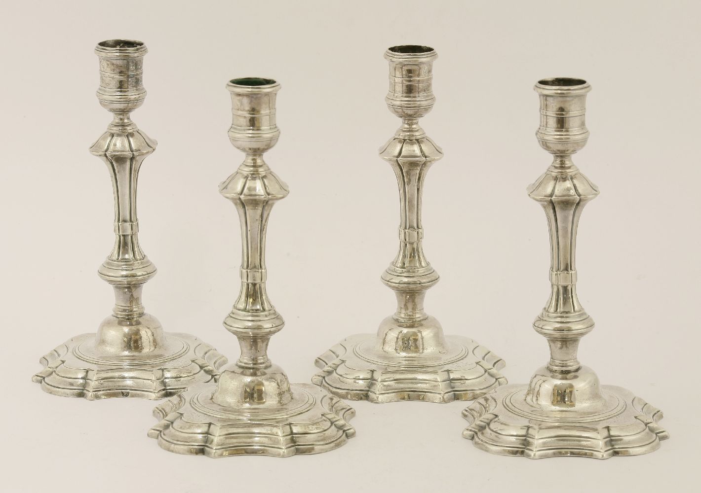 Four III Irish silver candlesticks,Robert Calderwood, Dublin, c.1770,the fluted stems on s