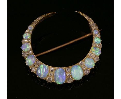 A Victorian gold, opal and diamond closed crescent brooch,with a row of graduated oval, cabochon opals.  Sets of three gradua