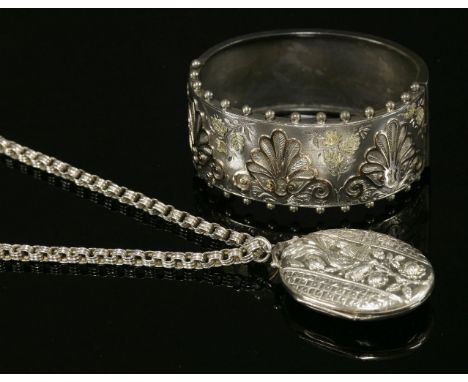 A late Victorian, sterling silver, oval, hinged locket and chain, c.1880,the locket with a central repoussé band depicting bi