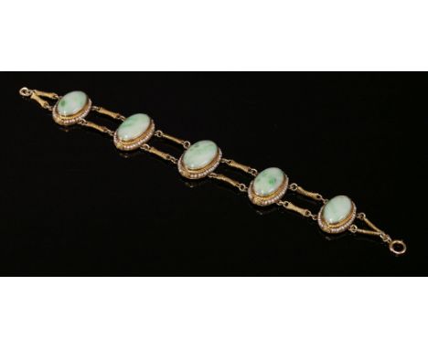 An American jade and seed pearl bracelet,with five graduated oval jade cabochons, each one rub set in a portrait position, a 
