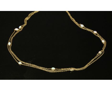 An Edwardian gold cabochon opal set long chain, later converted to a three row necklace.  A series of oval, cabochon opals, s