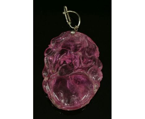 A Chinese carved pink tourmaline pendant,depicting peaches and foliage to a later hinged wire bale.  Tested as sterling silve