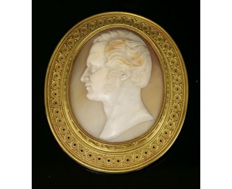 An Archaeological Revival gold shell cameo brooch, c.1865,by Castellani.  The oval carved shell cameo profile of a gentleman 