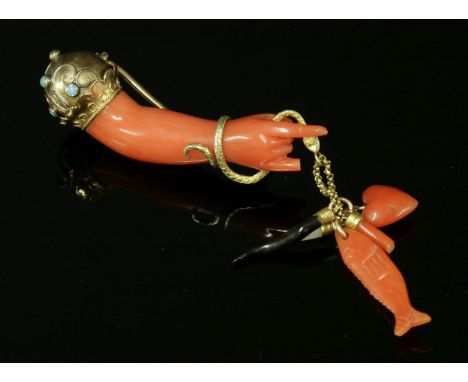 A Victorian gold, carved coral and turquoise set hand brooch, c.1870,the carved coral hand and arm with a globe and fluted cu