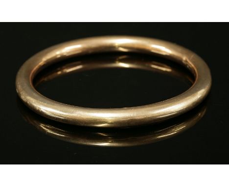 A 9ct gold hollow round section slave bangle,London 1920.  69mm interior diameter, 20.55g