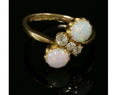 An 18ct gold Edwardian opal and diamond crossover ring,with two circular cabochon opals, claw set in shallow scalloped collet