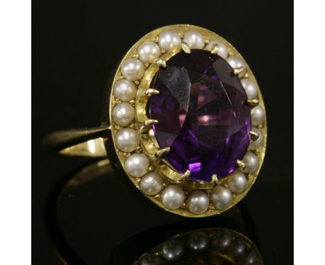 A gold amethyst and split pearl cluster ring,with an oval mixed cut amethyst, claw set to the centre, surrounded by a row of 