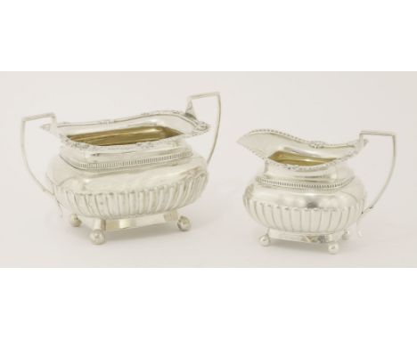 A Victorian silver sugar bowl and milk jug,Alfred Benson and and Henry Hugh Webb, London, 1893, the partly gadrooned bodies d