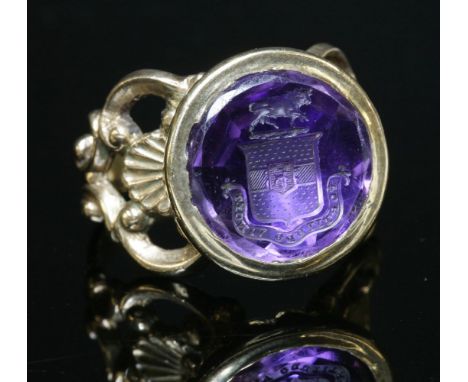 A gold mounted intaglio engraved amethyst seal,later mounted as a ring.  A circular amethyst matrix ring, seal engraved coat 