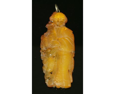 A Chinese carved amber pendant,depicting the immortal, Magu, holding an urn with a deer with pierced and incised decoration, 