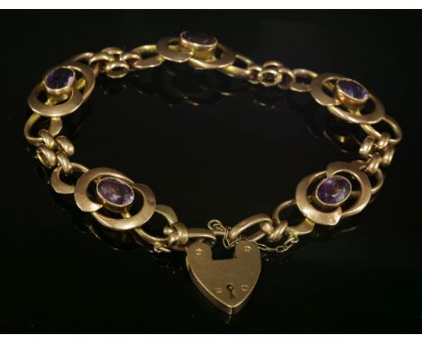 An Edwardian Art Noveau-style amethyst bracelet,with a series of scrolling whiplash-style plaques, each with an oval mixed cu