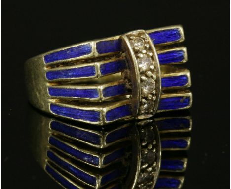 A Continental diamond and enamel ring, c.1970,with four flat section bands, decorated with royal blue enamel.  A concave head