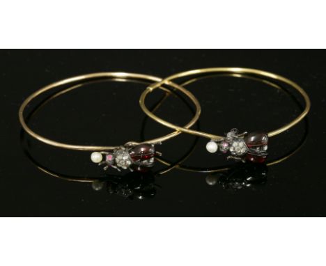 A pair of Victorian garnet, diamond, ruby and pearl set beetle or insect bangles,with hook clasps.  Each round wire gold bang