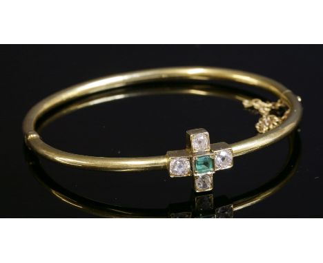 An Edwardian emerald and diamond cinquefoil cluster bangle, c.1905,a hollow tubular section hinged bangle.  A centrepiece com