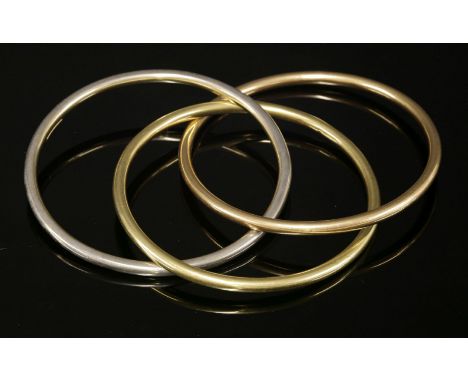 An Italian, hollow, Russian wedding ring-style bangle,with three interlocking, hollow, tubular bangles, in rose, white and ye