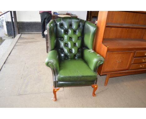 A green leather upholstered button back wing back armchair AF