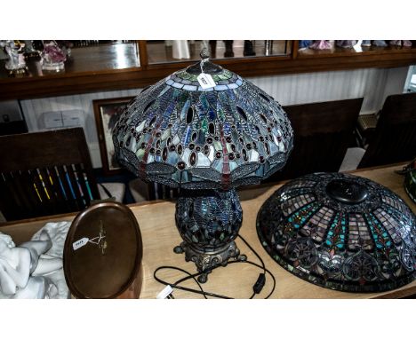Large Tiffany Style Lamp in shades of blue, with a bulbous decorated base raised on four decorative metal feet.  Fitted for t
