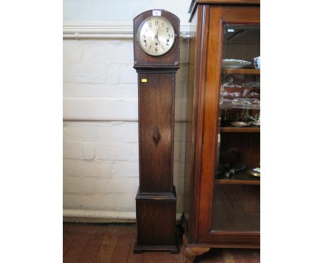 A 1930s oak miniature longcase clock, with silvered dial, the three train movement striking on gongs, 128 cm high