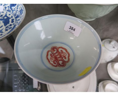 A Chinese red overglazed porcelain bowl, with foliate scroll motifs, six character mark on the base, 15 cm diameter 