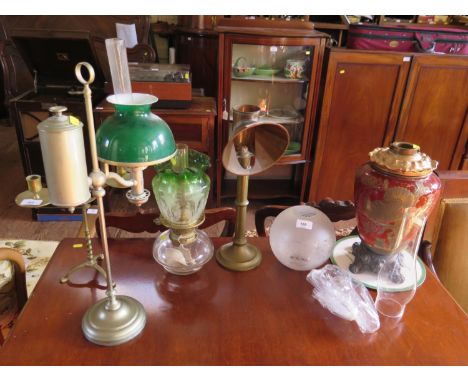 A Victorian brass candle desk lamp, 41.5 cm, a William H. Honey white metal table oil lamp, 57 cm high, another oil lamp and 