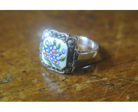 SILVER AND ENAMEL RING: A  silver ring with square enamelled centre in pretty blue floral design. Bordered by a single row of