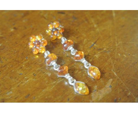 AMBER FLOWER DROP EARRINGS: A pair of pretty white metal and amber flower earrings with stud fastening and a 2'' drop. Set wi
