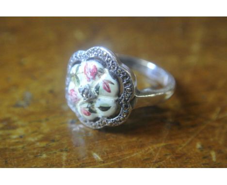 SILVER AND ENAMEL RING: A  silver ring with flower shaped enamelled centre in pretty pink floral design. Bordered by a single