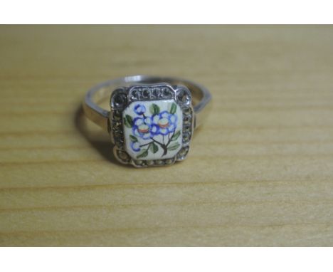 SILVER AND ENAMEL RING: A  silver ring with square enamelled centre in pretty blue floral design. Bordered by a single row of