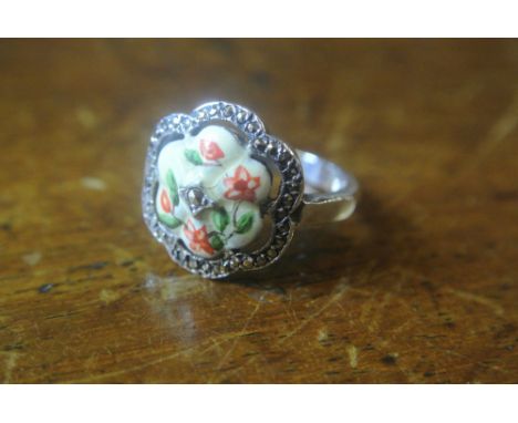 SILVER AND ENAMEL RING: A  silver ring with flower shaped enamelled centre in pretty coral  floral design. Bordered by a sing