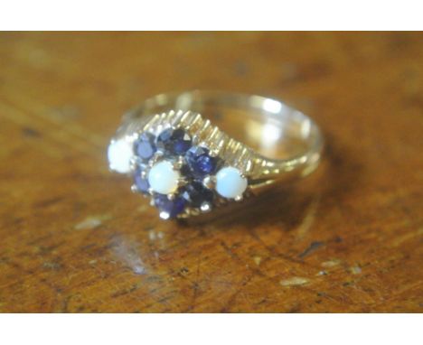 9CT GOLD SAPPHIRE & OPAL DAISY DIAMOND SHAPE RING: A stunning 9ct gold floral design ring set with  a opal to the centre surr