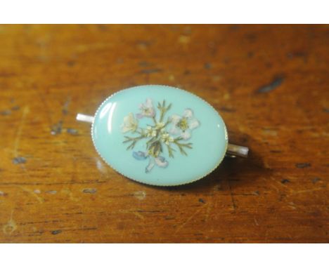 VINTAGE BLUE BAR BROOCH WITH PRESSED FLOWERS: A charming light blue oval brooch on bar form measuring approx. 1.3'' across by