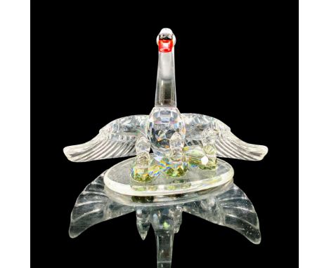A clear crystal swan with open wings protecting her three babies swimming in front of her. Amber and black crystal used for t