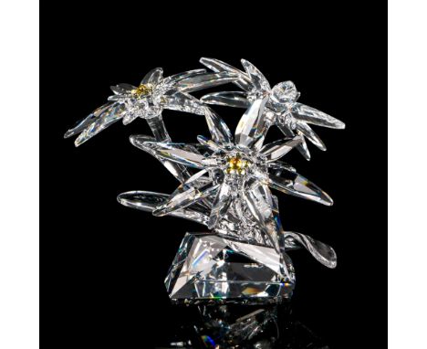 A clear crystal figure of an Edelweiss plant with three flowers in bloom with yellow crystal used for the centers. Swarovski 