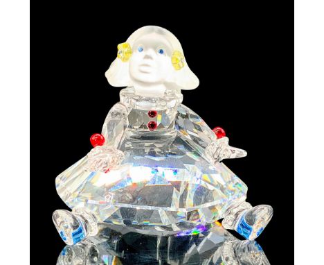 A figure that depicts a female doll with a frosted glass head and red, blue, and yellow crystal used for accessories througho