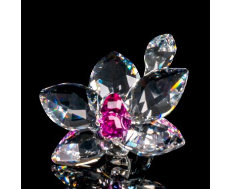 A clear crystal figure of an orchid flower in bloom with an amethyst-colored crystal used for the column of the flower. Swaro