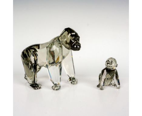 A pair of black crystal figures that depict a parent and baby gorilla with the parent gorilla standing on all fours and the b