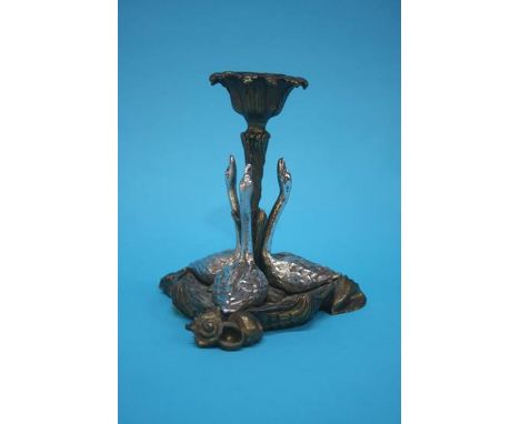 A Continental brass candlestick, mounted with white metal swans