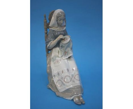 A large Lladro figure of a seated lady embroidering