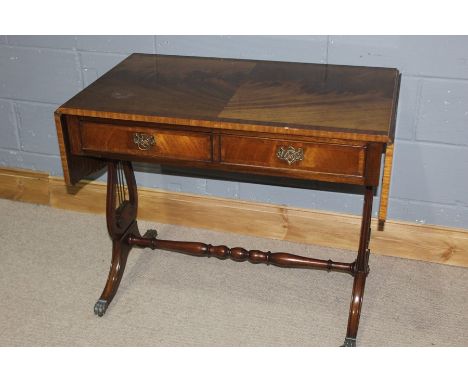 Regency style mahogany sofa table, with two leaves, raised on pierced lyre form supports, turned stretcher, on out-splayed re